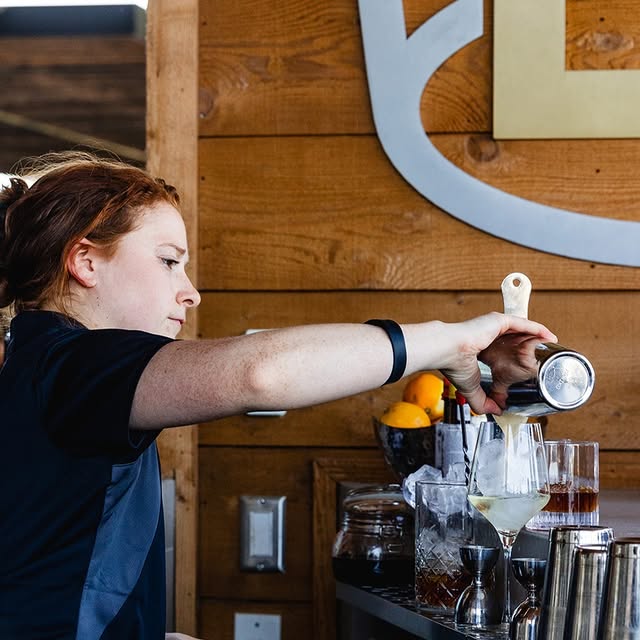 Bartender crafting a cocktail at Bardstown Bourbon Company with fresh ingredients and ice.